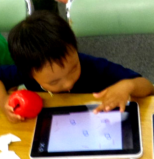 いきいきるん：ビジュアルプログラミング言語ビスケットでタブレットで絵を描いている幼児の様子